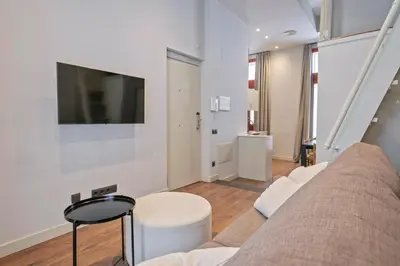 a living room with a couch and a tv on a wall at Uma Suites Barceloneta Beach in Barcelona