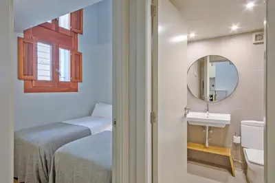 a bathroom with a bed and a sink and a mirror at Uma Suites Barceloneta Beach in Barcelona