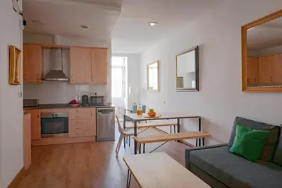 a kitchen and living room with a couch and a table at My Address in Sant Antoni in Barcelona