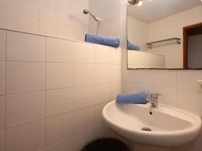 a white bathroom with a sink and a mirror at Apartment Zodiak by Interhome in Pineda de Mar
