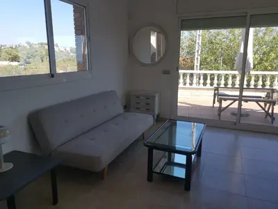 a living room with a couch and a glass table at CAN TRULLEN CHALET CALAFELL in Calafell