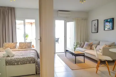 a living room with a bed and a couch at Camelot Apartment by Hello Homes Sitges in Sitges