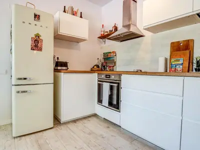 a kitchen with white appliances and a refrigerator at Simba Apartment by Hello Homes Sitges in Sitges