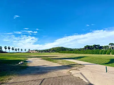 an empty road in a park with palm trees at Simba Apartment by Hello Homes Sitges in Sitges