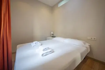 a bedroom with a white bed with two towels on it at Catalunya Casas 2 bed apartment in Barceloneta steps from the beach in Barcelona