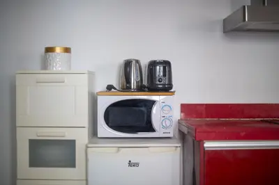 a kitchen with a microwave on top of a refrigerator at Catalunya Casas Pied-à-terre in central Barcelona 100m from beach in Barcelona