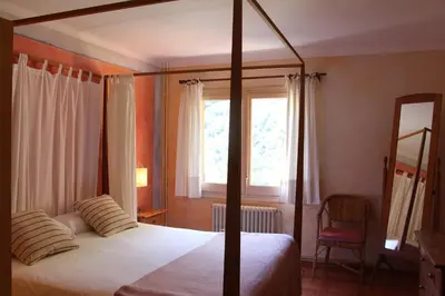 a bedroom with a bed and a window and a mirror at Hostal l´Ou de Reig in Montseny