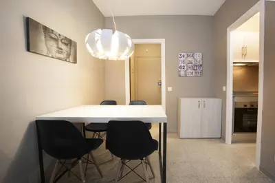 a dining room with a white table and black chairs at Bcn Sagrada Familia Apartments in Barcelona