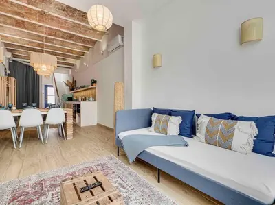 a living room with a blue couch and a dining room at Casa Mandarina: 4 Bedrooms - 2 Terraces - Parking in Hospitalet de Llobregat