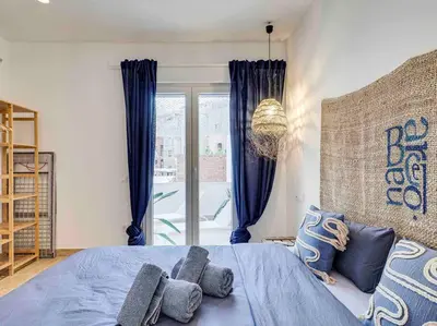 a bedroom with a blue bed and a large window at Casa Mandarina: 4 Bedrooms - 2 Terraces - Parking in Hospitalet de Llobregat
