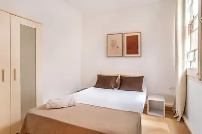 a bedroom with a bed in a white room at The Collection Barcelona - Paseo St Joan classic 4BD for 10 guests in Barcelona