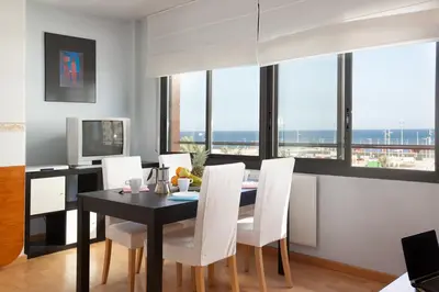 a dining room with a black table and white chairs at Splash in Barcelona