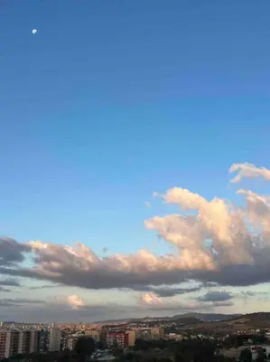 a group of clouds in the sky over a city at Casa familiar en la playa con piscina in Teià