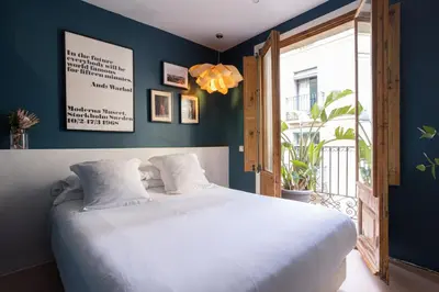 a bedroom with a large white bed and a window at Hostal Sol y K in Barcelona