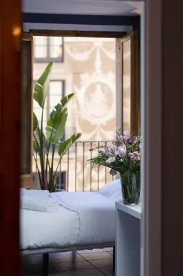 a bedroom with a bed and a window with flowers at Hostal Sol y K in Barcelona