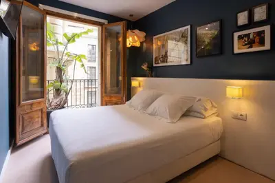 a bedroom with a white bed and a window at Hostal Sol y K in Barcelona