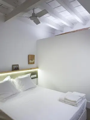 a white bed with white pillows and a ceiling at Best House Best Place in Barcelona