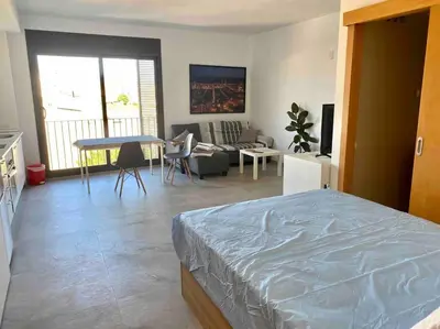 a bedroom with a bed and a table in it at Modern Loft in Terrassa in Terrassa