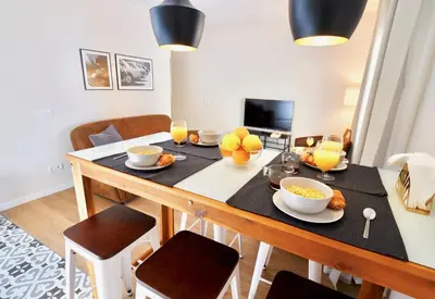 a dining room with a table with food and drinks at MadreMia - Chic Hub Barcelona in Hospitalet de Llobregat