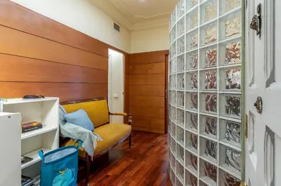 a room with a yellow chair and a wall of glasses at Canela Homes BARCELONA JARDINETS in Barcelona