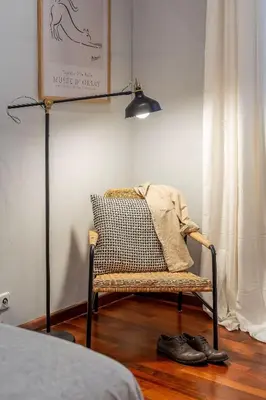 a room with a chair and a lamp and a bed at Canela Homes BARCELONA JARDINETS in Barcelona