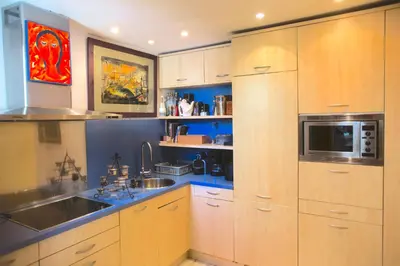 a kitchen with wooden cabinets and a sink and a microwave at Tot Gaviota in Sitges