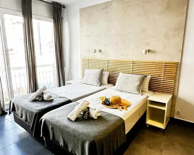 two beds in a hotel room with towels on them at Villa Sagrada in Barcelona