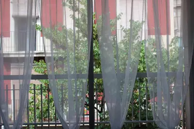 a window with curtains in front of a fence at Villa Sagrada in Barcelona