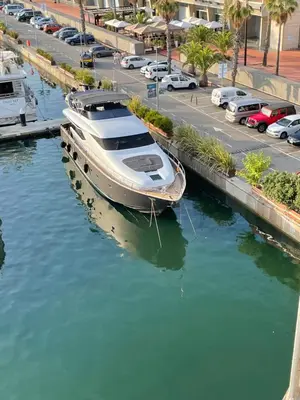 a boat is docked in a river next to a parking lot at MotorYacht 21 avec équipage in Barcelona