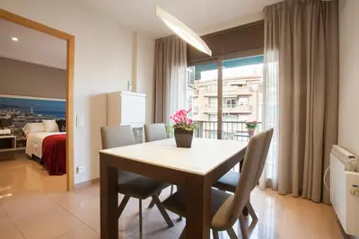 a dining room with a table and chairs and a bedroom at Rosselló Apartment in Barcelona