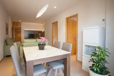 a dining room and living room with a table and chairs at Rosselló Apartment in Barcelona