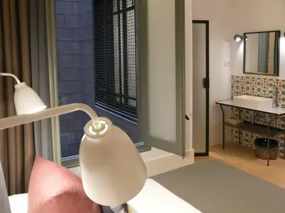 a bedroom with a bed with a lamp and a window at Casa Mathilda in Barcelona