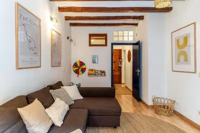 a living room with a brown couch and white walls at Canela Homes BARCELONA SANT ANTONI in Barcelona