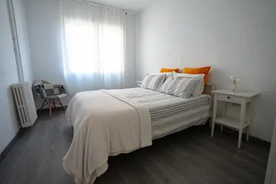 a white bedroom with a bed and a window at Flat Top Manager in Barcelona