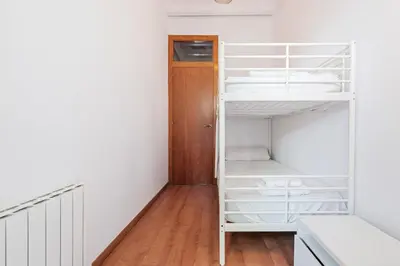 a room with white bunk beds and a wooden floor at Bright 2BR in Clot Desk Fiber Wi-Fi in Barcelona