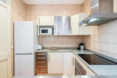 a kitchen with a white refrigerator and a microwave at Bright 2BR in Clot Desk Fiber Wi-Fi in Barcelona