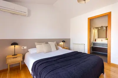 a bedroom with a large bed and a bathroom at Elegante dúplex en Terrassa, Barcelona in Terrassa