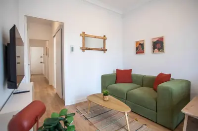 a living room with a green couch and red pillows at 52PAR1012 - Magnific 3BR Apartment in Paralel in Barcelona