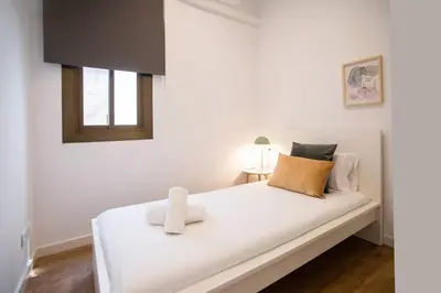 a white bed with two towels on it in a room at 52PAR1012 - Magnific 3BR Apartment in Paralel in Barcelona