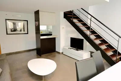 a living room with a white table and a staircase at Homenfun Barcelona Paseo de Gracia Diagonal in Barcelona