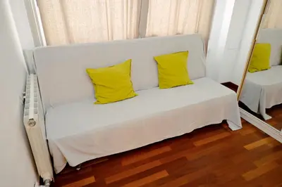 a white couch with two yellow pillows in a room at Homenfun Barcelona Paseo de Gracia Diagonal in Barcelona