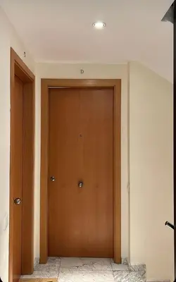 a hallway with a wooden door in a house at M1 Céntrico y con balcón in Terrassa