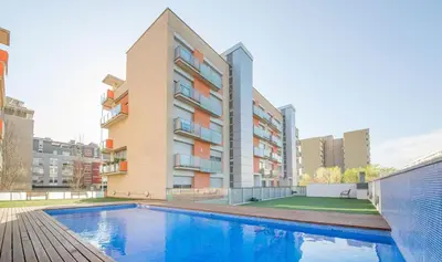 a swimming pool in front of a building at Family apartment Forum in Sant Adria de Besos