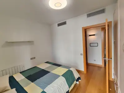 a bedroom with a bed and a door to a hallway at Family apartment Forum in Sant Adria de Besos