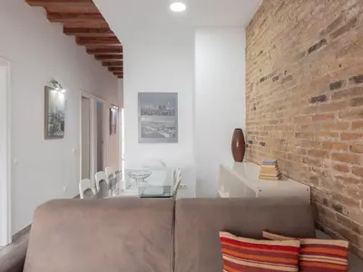 a living room with a couch and a brick wall at Stay U-nique Apartments Nació in Barcelona