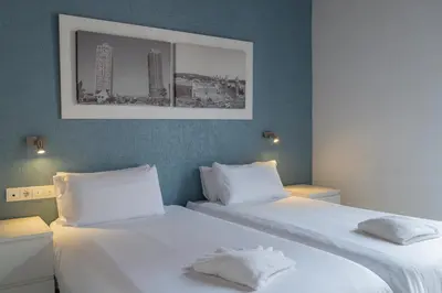 two beds in a hotel room with white sheets at Stay U-nique Apartments Nació in Barcelona