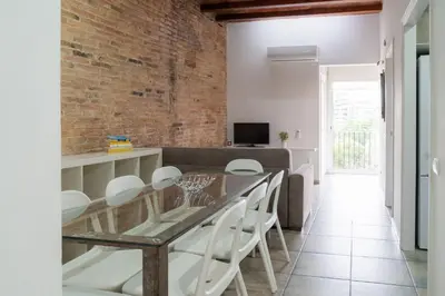 a dining room with a glass table and white chairs at Stay U-nique Apartments Nació in Barcelona