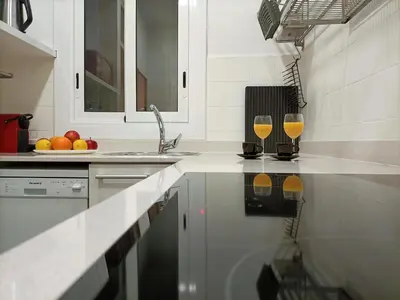 a kitchen with two glasses of wine on the counter at Suitur apartamento floridablanca barcelona in Barcelona