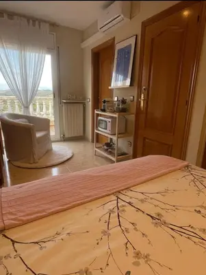 a small kitchen with a table and two stools at Habitación Atalaya in Olivella