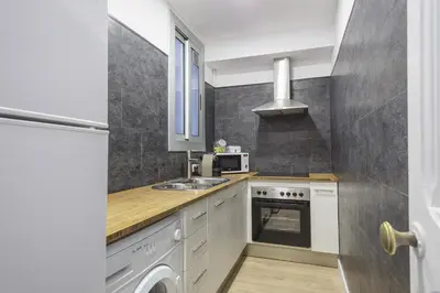 a small kitchen with a sink and a microwave at The White Flats Eixample in Barcelona